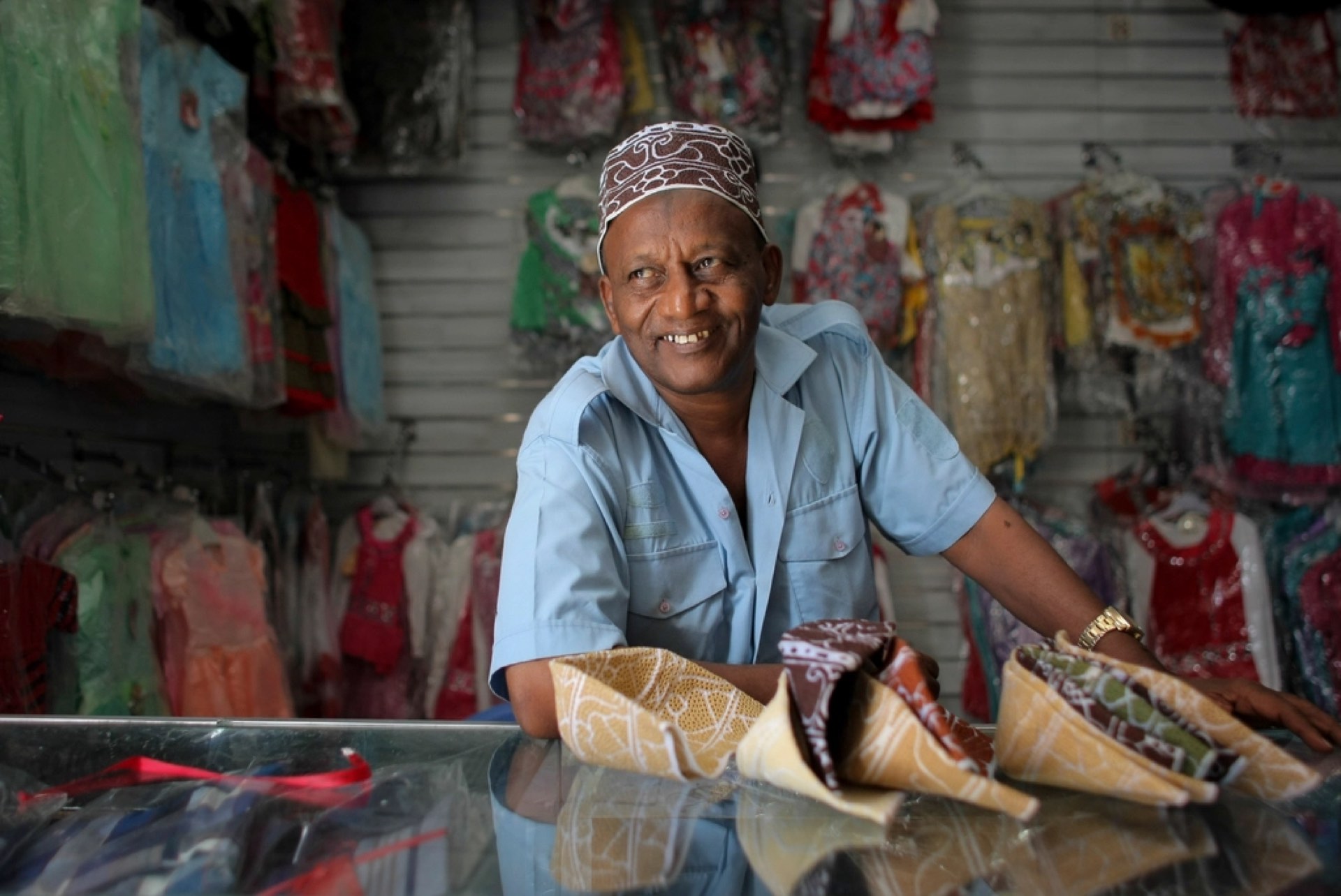 A smiling shopkeeper in his fabric shop