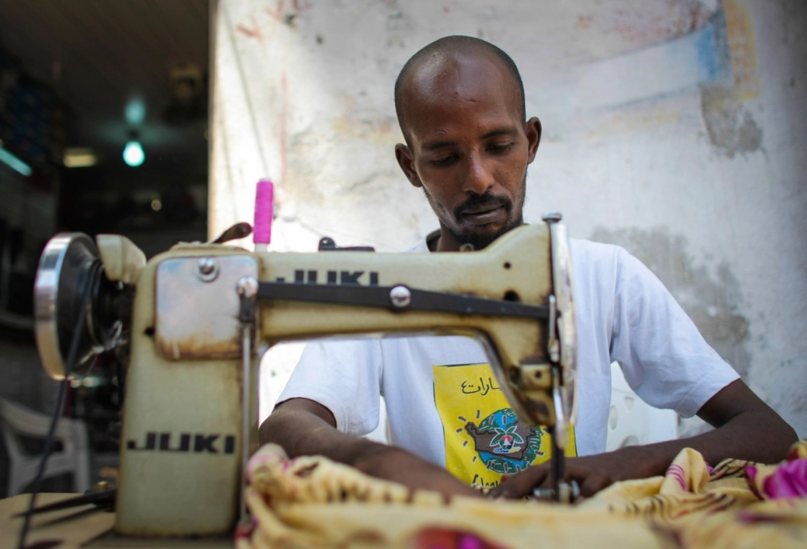 A tailor working at his sewing machine