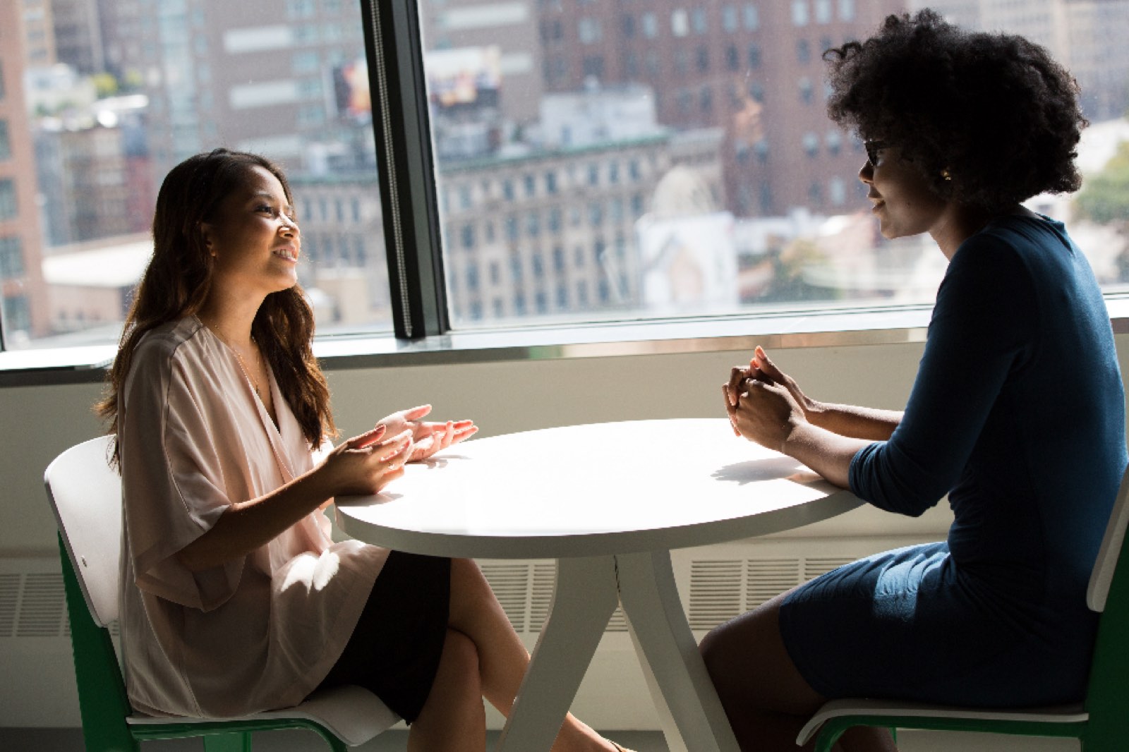 Two women talking over coffee at work