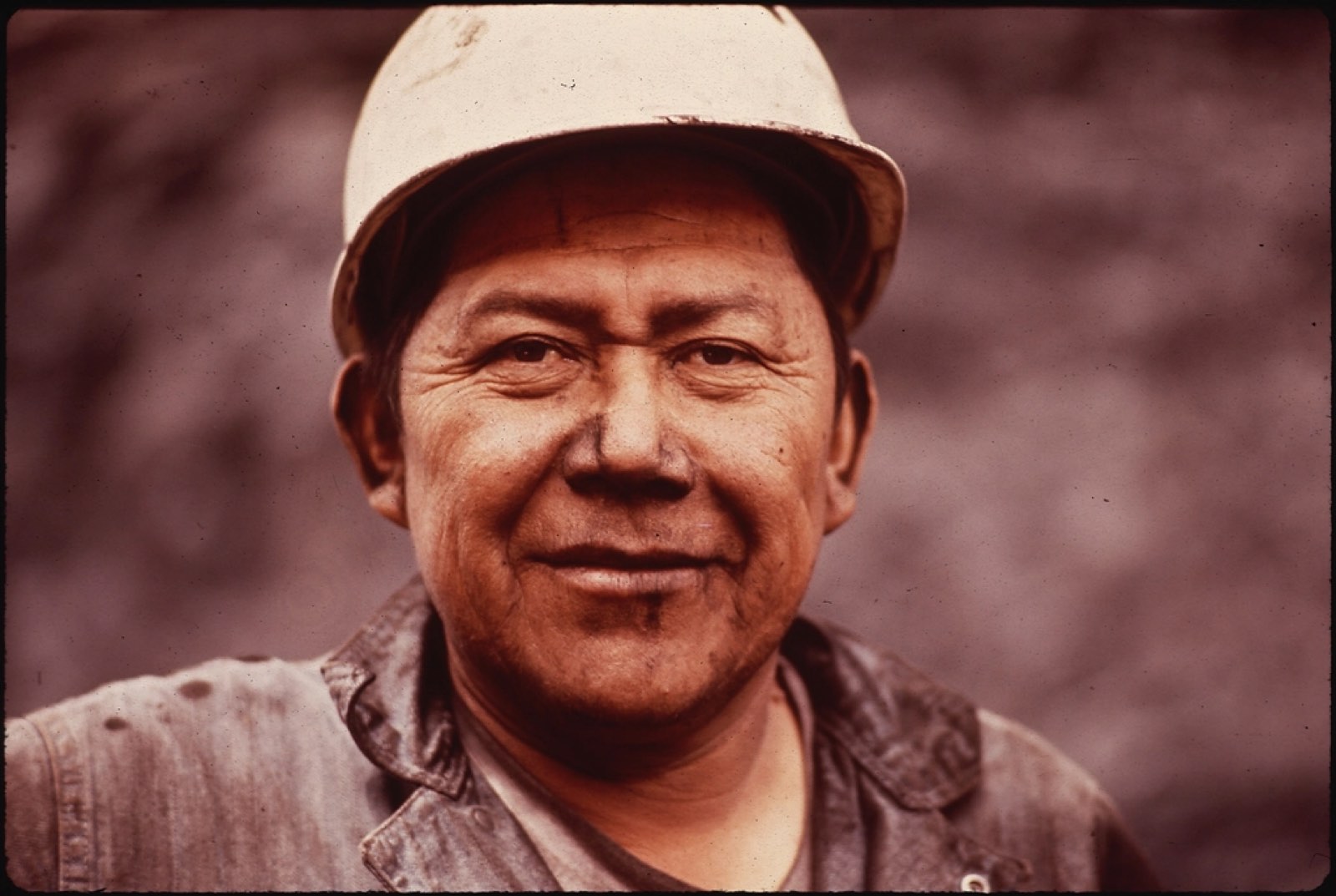 A smiling worker in a hard hat